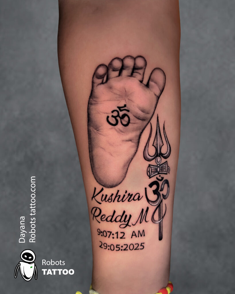baby foot print with script and thrisula tattoo